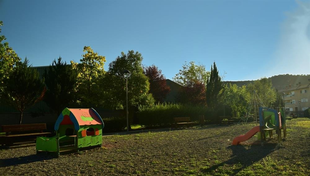 Parque exterior con zona de juegos infantiles